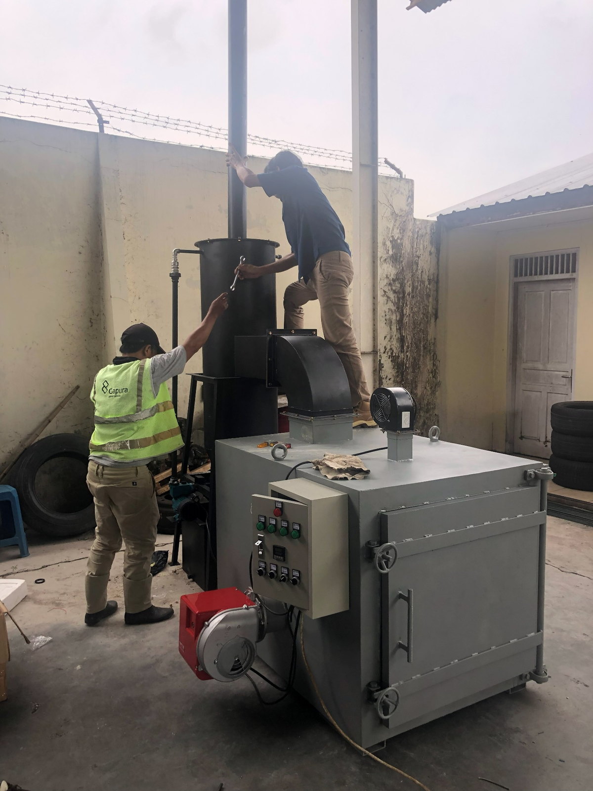 Unit incinerator, blower, dan panel kontrol di area instalasi